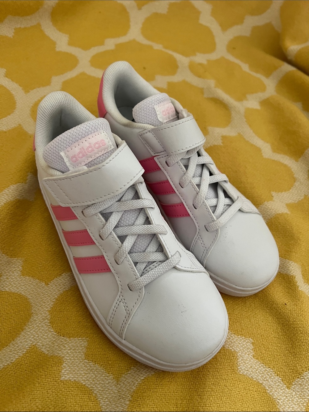 adidas Kids White Sneakers with Pink Stripes.